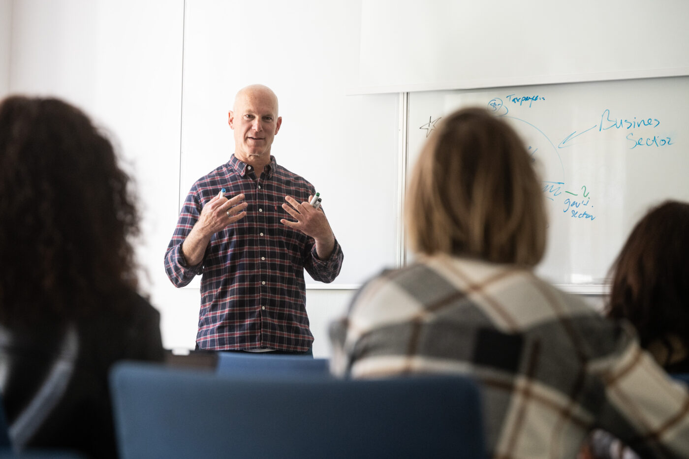 A UNYP professor explains the business side of analytics management to a graduate class.