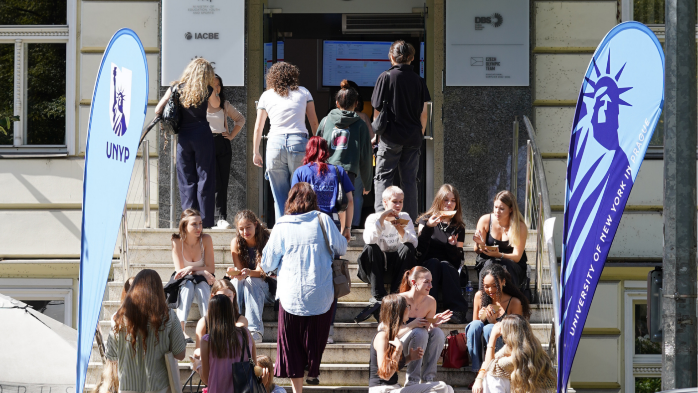 Students walking into the University of New York in Prague building during a during an orientation day event.